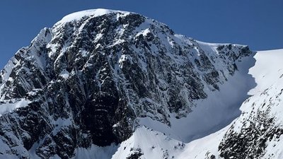 Snow-covered mountain peak under a clear sky, no people or equipment visible.