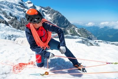 A mountain guide demonstrates a pulley system on the glacier.