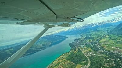 Blick aus dem Skydive-Flugzeug über Reichenbach auf den Thunersee und die Schweizer Alpen im Sommer.