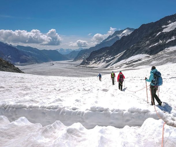 Seilschaft Gletscherwanderer wandert auf dem verschneiten Jungfraufirn Richtung Konkordiaplatz