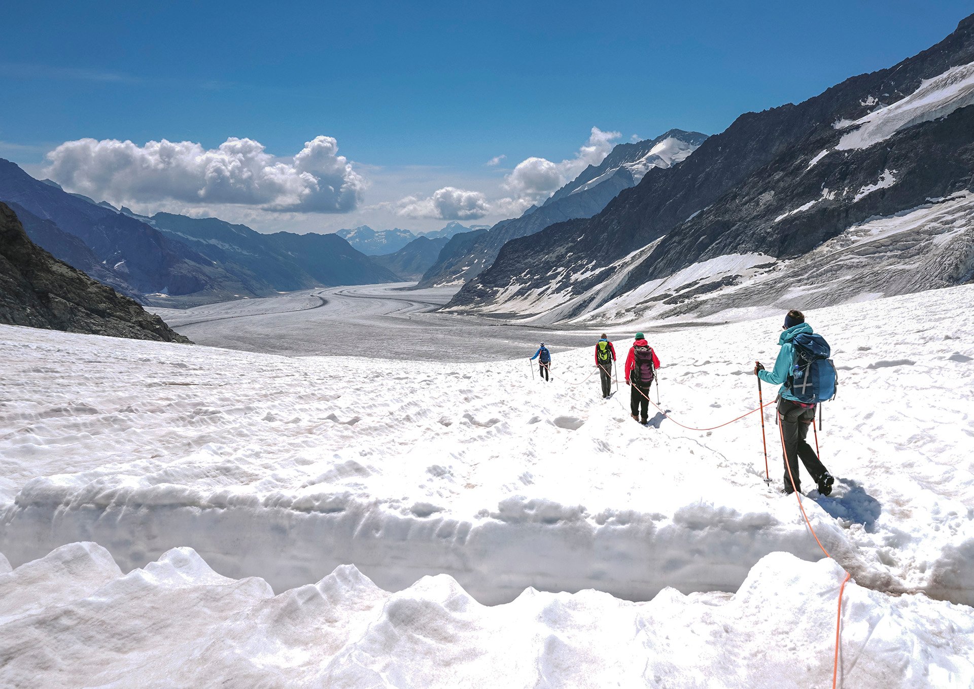 Seilschaft Gletscherwanderer wandert auf dem verschneiten Jungfraufirn Richtung Konkordiaplatz