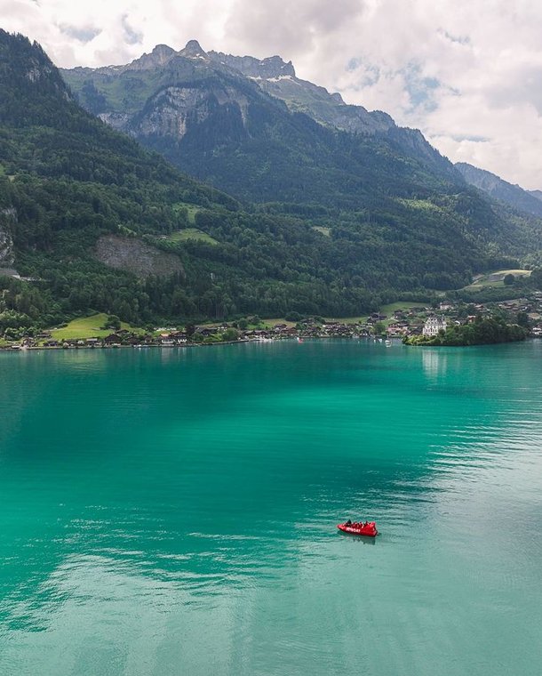 Jet boat on the turquoise blue Lake Brienz in front of Iseltwald.
