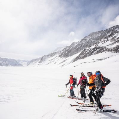 Mehrere Personen stehen mit Tourenskis auf dem Gletscher an der Lötschenlücke