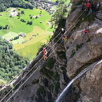 Several people crossing a rope bridge on the Allmenalp via ferrata.