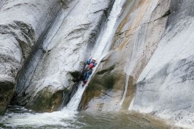 Person rutscht Wasserfall beim Canyoning Chli Schliere hinunter