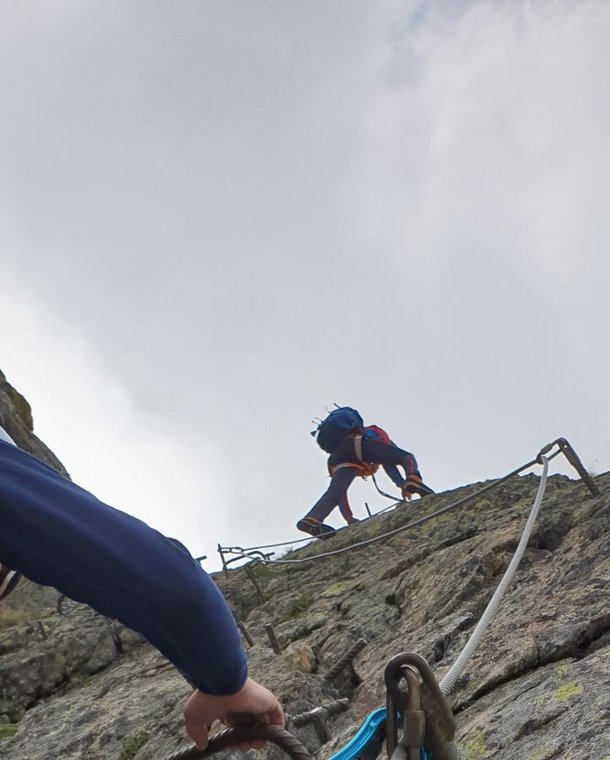 Person climbs a vertical section of the Tierbergli via ferrata