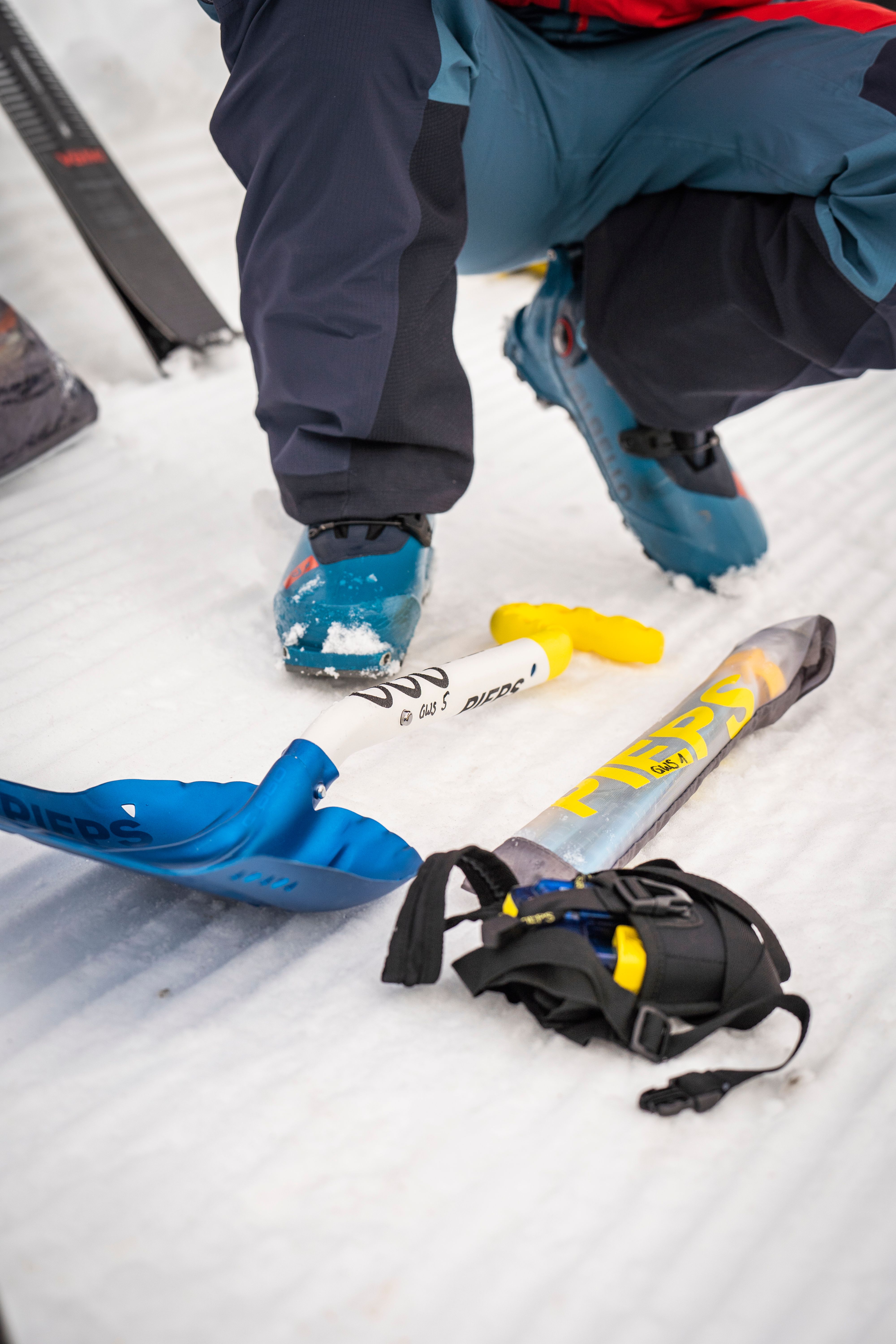 Lawinenschaufel, Lawinensonde und Lawinenverschüttetensuchgerät im Schnee