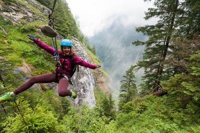 Woman on zip line in the forest.
