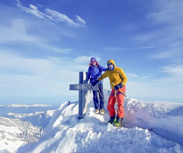 Ski tourers at the summit cross of the Finsteraarhorn.