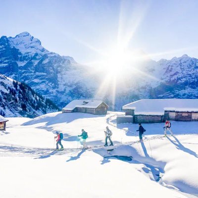 Skitourengänger im Aufstieg bei Alphütten mit dem Wetterhorn im Hintergrund