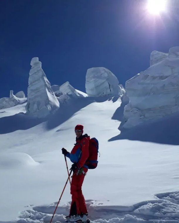 Ski tourers on the glacier with ice blocks in the background.