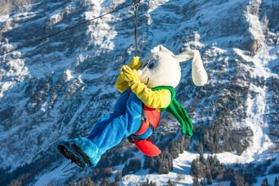 Snowli auf Seilrutsche in verschneiter Berglandschaft in Grindelwald.