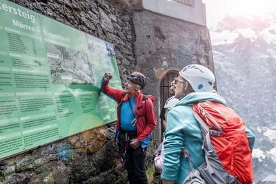 Bergführer erklärt die Route des Klettersteigs Mürrens auf der Karte. Die Gäste schauen zu.