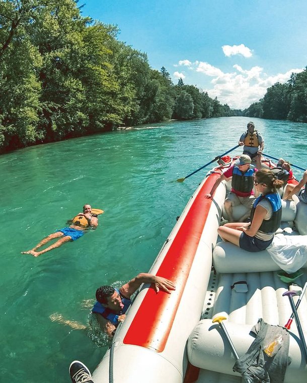 People on a raft during the Aare river cruise, some participants let themselves drift next to the boat