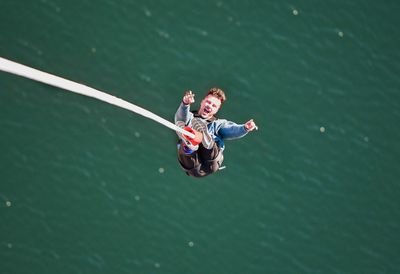 Nahaufname einer Person beim Bungee Jumping über dem Wasser
