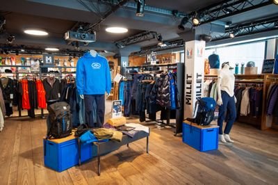 Outdoor-Shop mit Schaufensterpuppen, Jacken, Rucksäcken, Markenregalen (Millet) und Holzfußboden