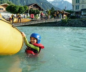 Child swims after the family rafting in the turquoise blue Lake Brienz.