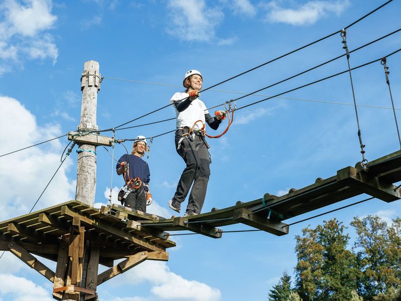 Person walks across a wooden bridge in the Rigi Rope Park