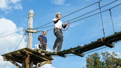 Person walks across a wooden bridge in the Rigi Rope Park